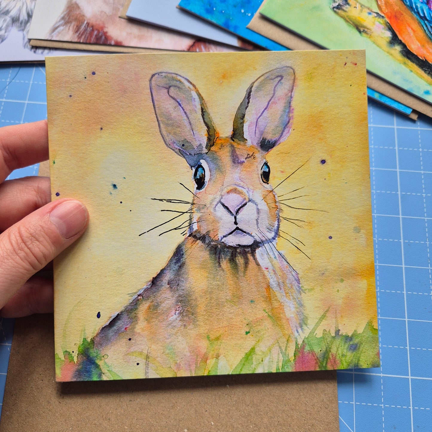 Hare greeting card with whimsical animal artwork held in hand with kraft envelope