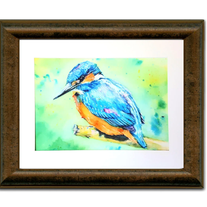 "A framed A4 kingfisher art print, featuring a watercolour wildlife illustration. The detailed brushstrokes and vibrant colours make it a perfect nature-inspired décor piece."
