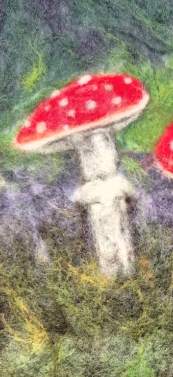 Detailed wool texture on a red and white needle-felted mushroom