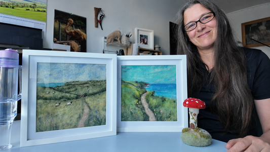Justine with two framed needle-felted Devon landscapes and the Garden at Toadstool House