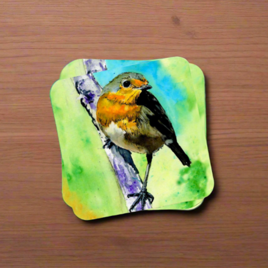 "A square glossy coaster on a wooden surface, featuring a print of an original watercolour painting by artist Jagos Art. The artwork depicts a vibrant robin perched on a branch against a lush green background."