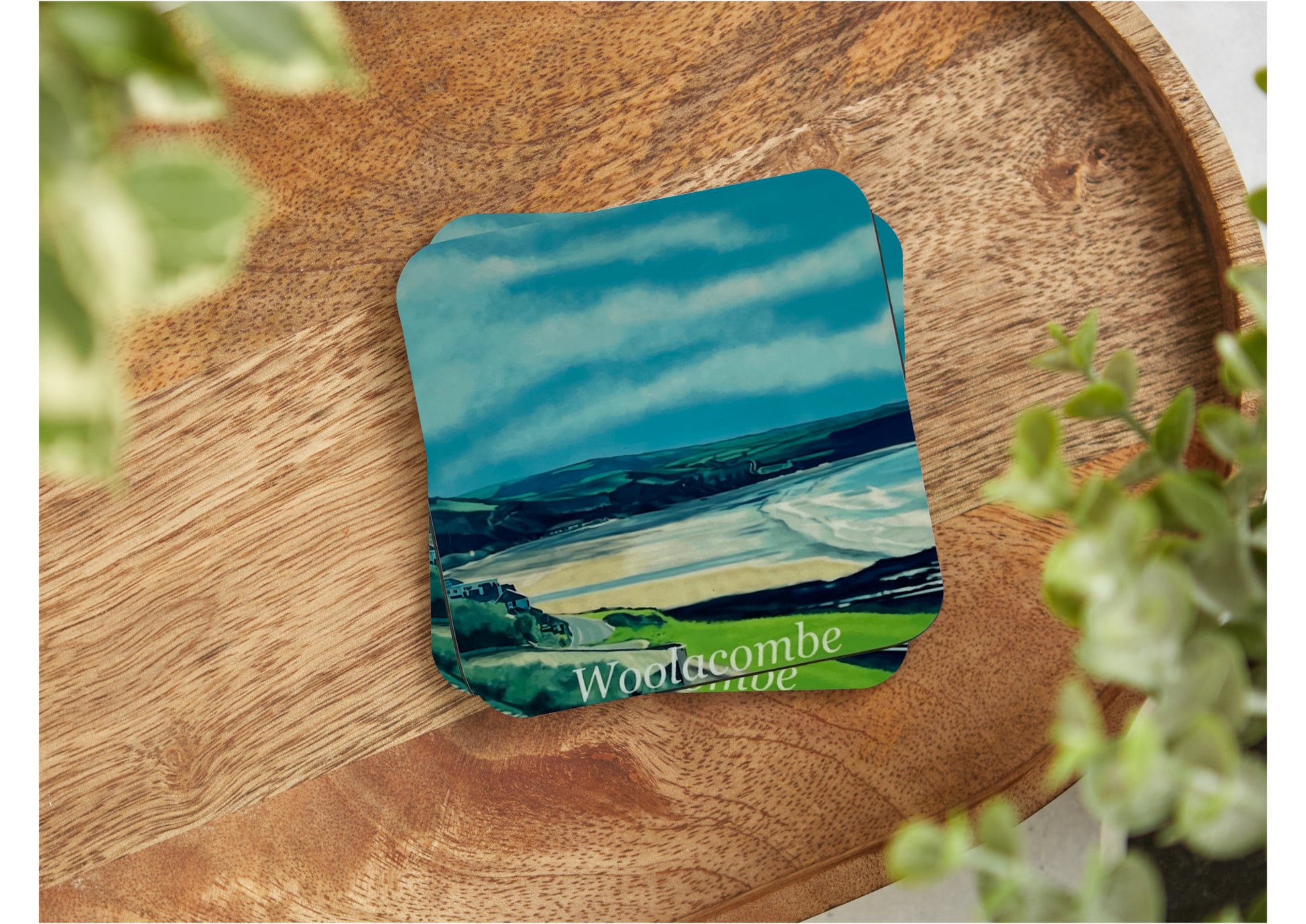 A table coaster featuring a print of Woolacombe Beach showing the Beach from the road and the field landscape in the distance