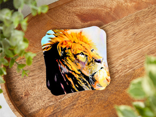 A coaster featuring a print of an original watercolour painting of a stunning Lion with a majestic look on his face and a golden mane primary colours being tones of yellow and orange