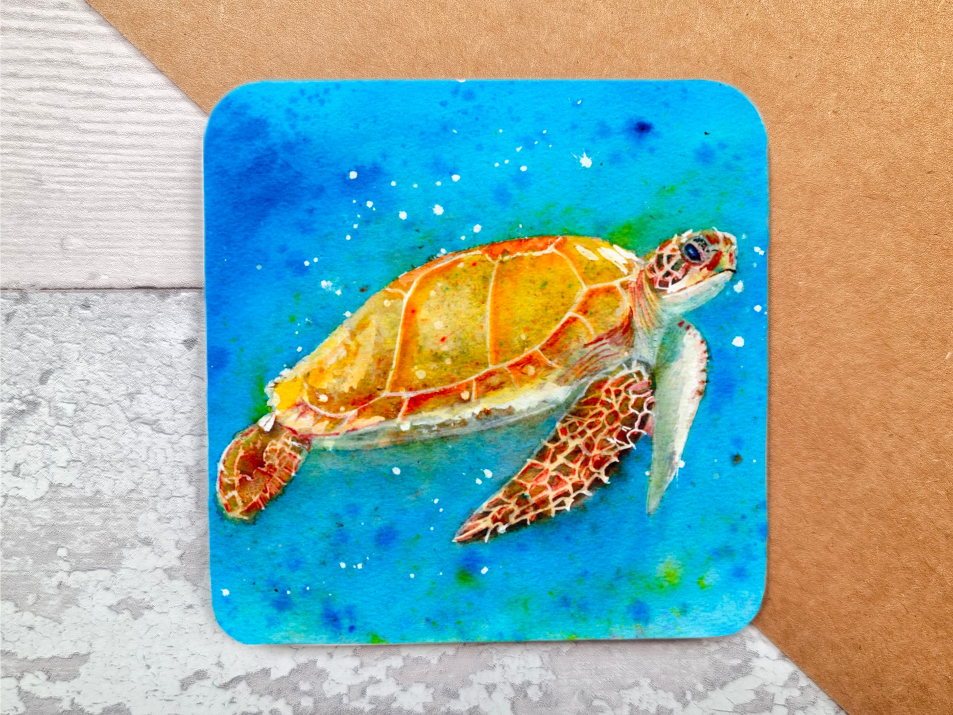 A coaster featuring a print of an original mixed media painting of a stunning Sea Turtle swimming in the beautiful vibrant blue sea