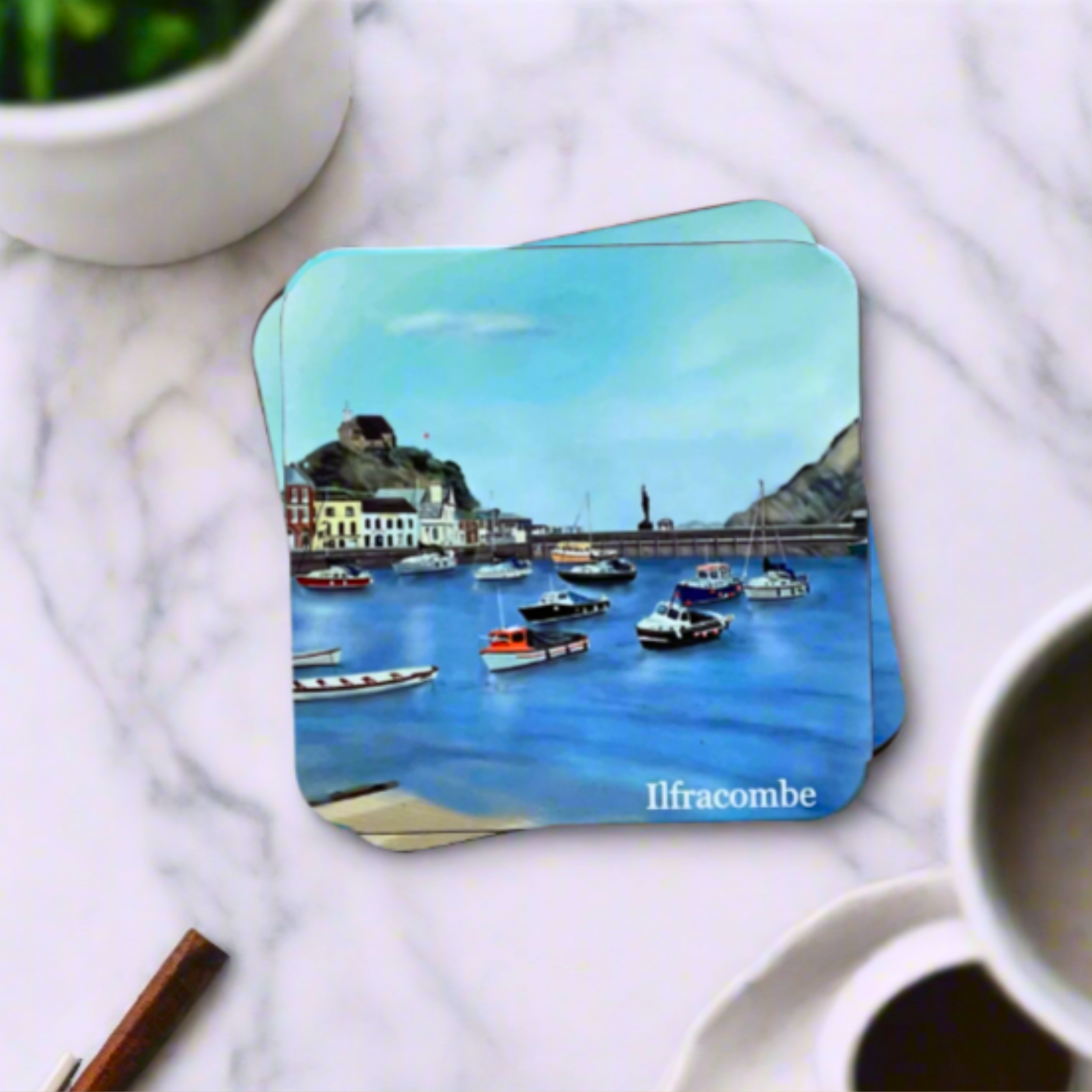 Ilfracombe coaster by Jagos Art with blue sea, blue sky, boats, church on the hill, verity statue on a marble table