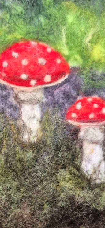 Close-up of red and white needle-felted mushrooms in a woodland scene