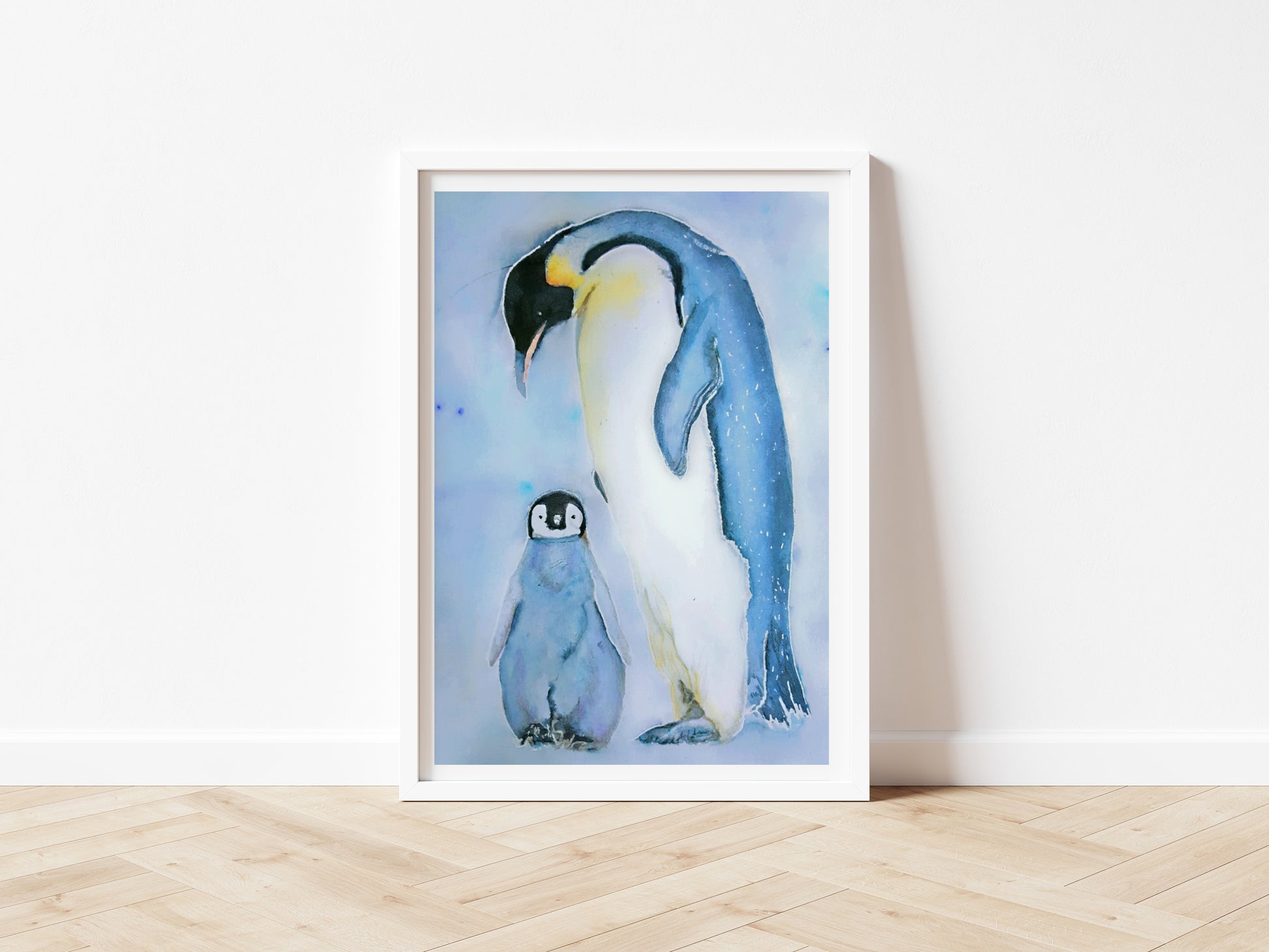 An art print of an original watercolour painting of a mother and baby penguin with the mother looking down over her young baby painted in the primary colours of blue white and yellow