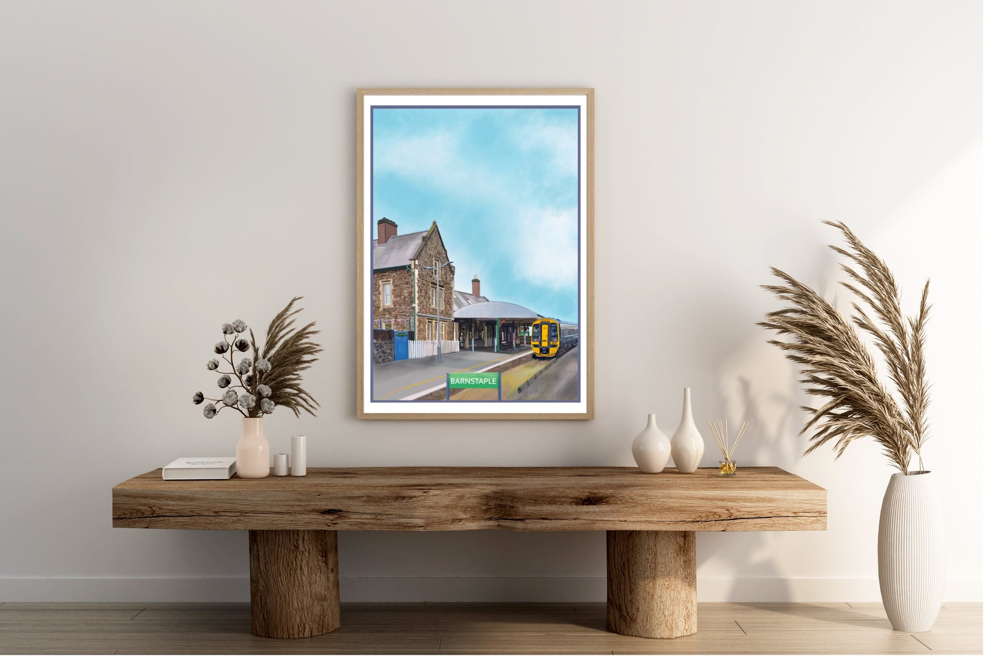 An art print by Jagos Art of Barnstaple Railway Station in North Devon England featuring the Station Masters House Cafe and a train which has arrived at the platform