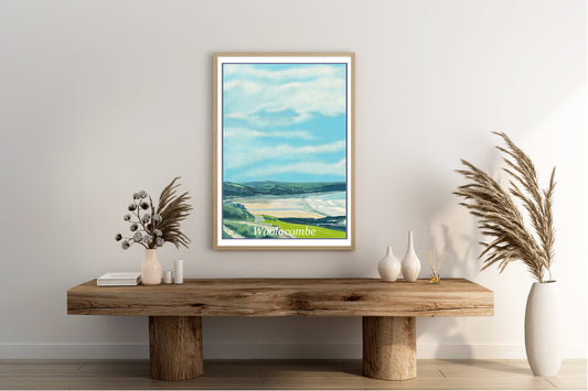 An art print of Woolacombe in North Devon England featuring the beach from a distance and the hillside and cliffside surrounding the beach painted in the style of the old vintage railway poster